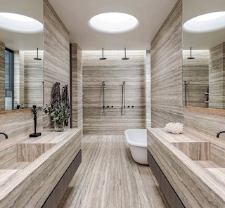 Travertine bathroom with twin showers and freestanding bath